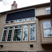 Retractable solar screen wall added on to large windows to block/protect the home from the west sun