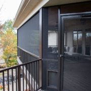 The exterior of an outdoor screen room addition with a door and a doggy door