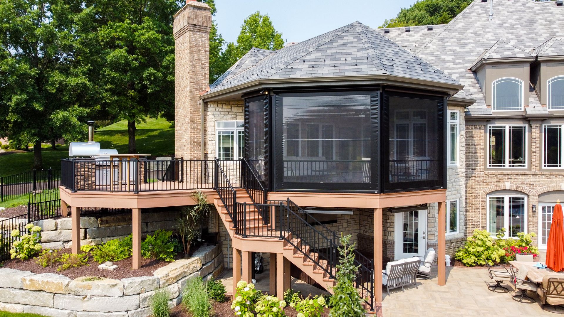 A unique screen room on a composite deck. The patio level includes an underdeck system and InfraTech heaters. The screen room includes Universal Motions retractable Vinyl walls.