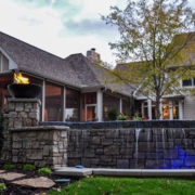 A beautiful screen room with an infinity pool and a fire feature