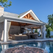 pool side outdoor room with an outdoor kitchen, fireplace, and pergola feature