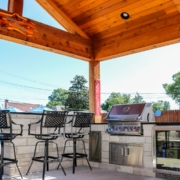 built in kitchen with seating in a pool side outdoor room