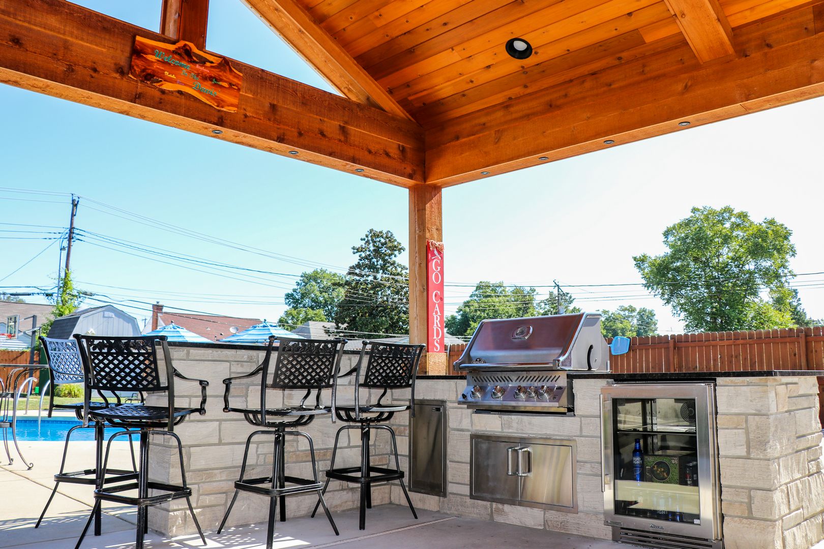 built in kitchen with seating in a pool side outdoor room