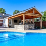 pool side outdoor room with an outdoor kitchen feature that has seating for up to five people