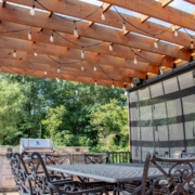 pergola next to a retractable screen room system located on a deck