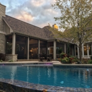 A custom screen room addition next to an infinity pool