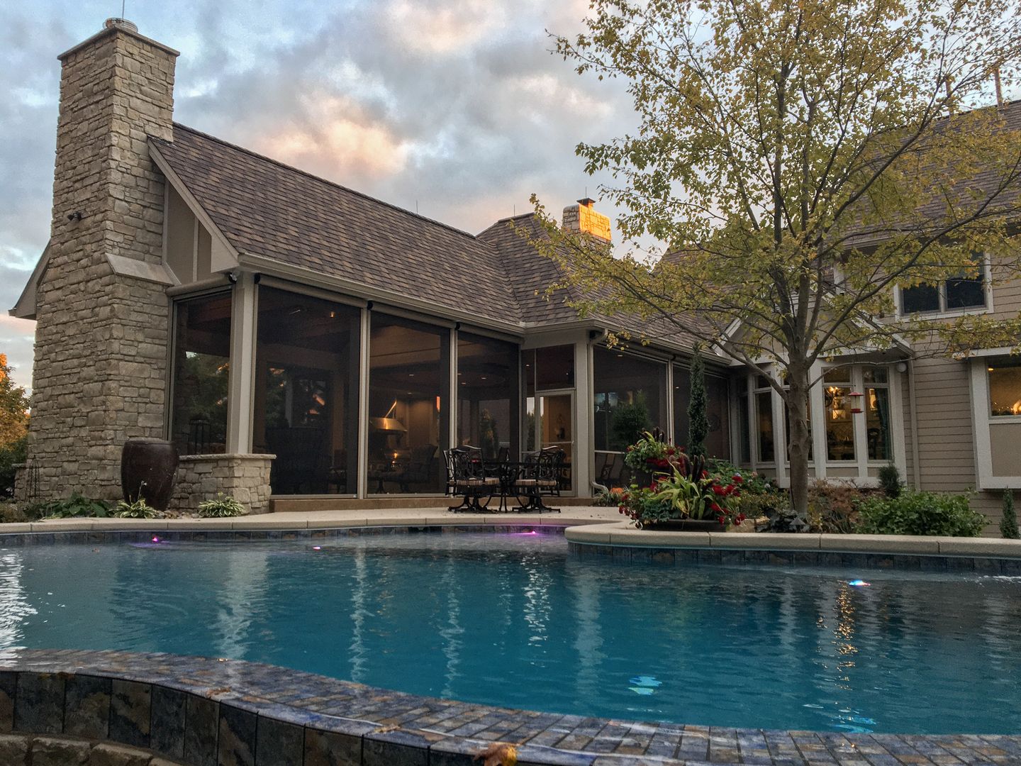 A custom screen room addition next to an infinity pool