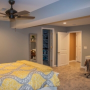 An unfinished portion of a basement transformed into a beautiful large bedroom with a spacious walk in closet