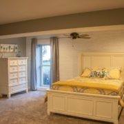 An unfinished portion of a basement transformed into a beautiful large bedroom with a spacious walk in closet