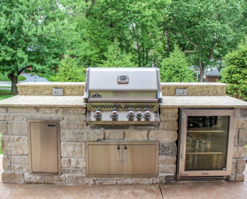 custom built in napoleon grill with a true refrigerator and stainless steel cabinets