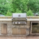 custom built in napoleon grill with a true refrigerator and stainless steel cabinets