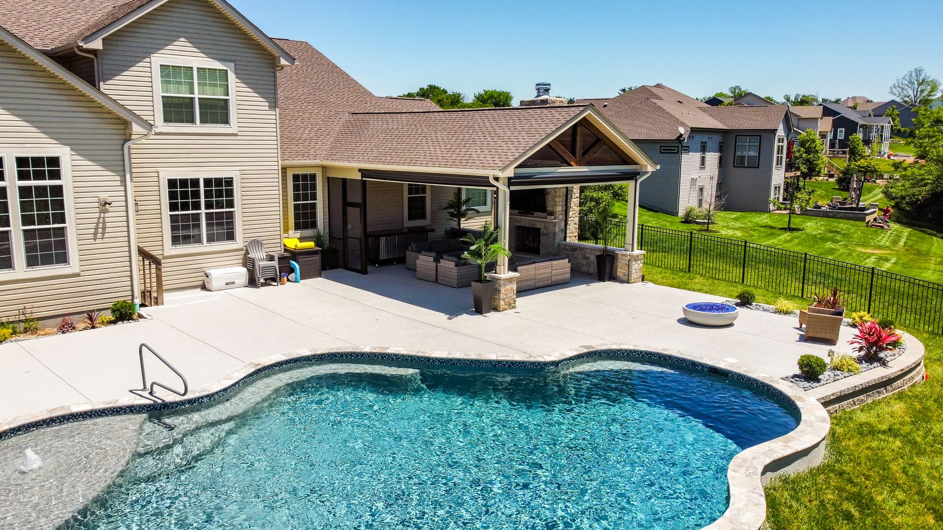 A custom unique outdoor pool house. This pool house includes a Fireplace with sitting walls on either side and stone accents.