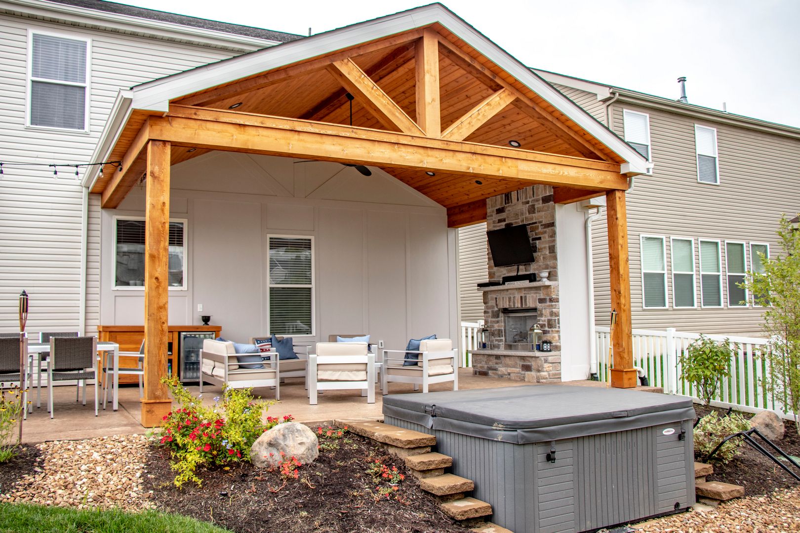 Covered outdoor room with comfortable seating by the fireplace