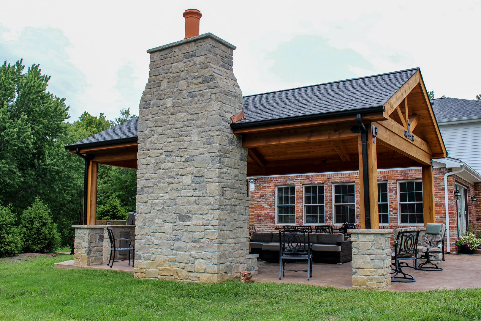 covered outdoor room with a fireplace