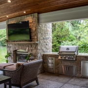 Outdoor kitchen next to a fireplace