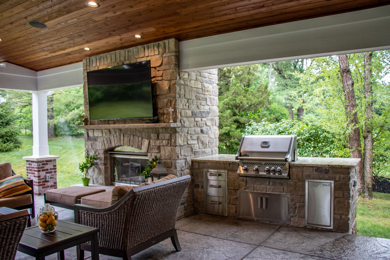 Outdoor kitchen next to a fireplace